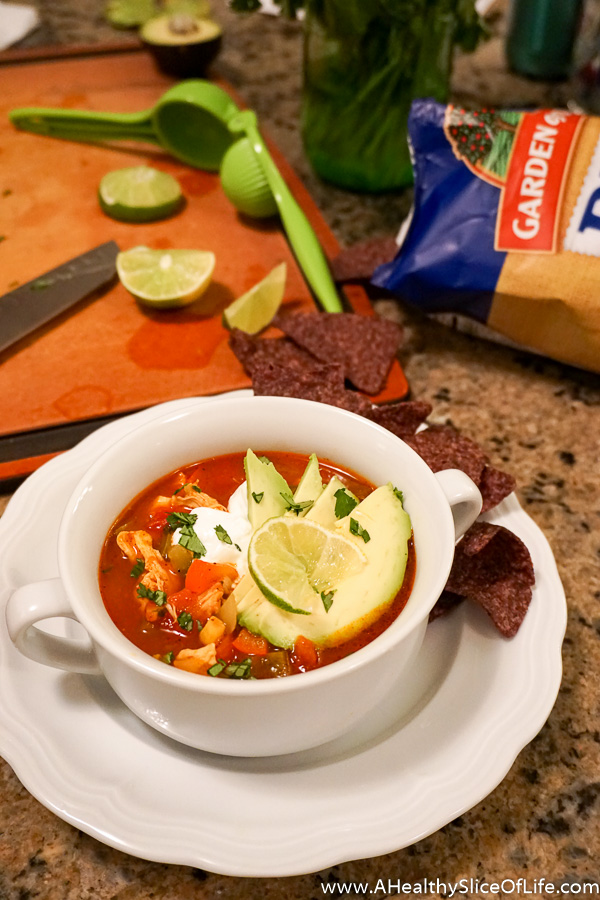 chicken tortilla soup in bowl with avocado and lime