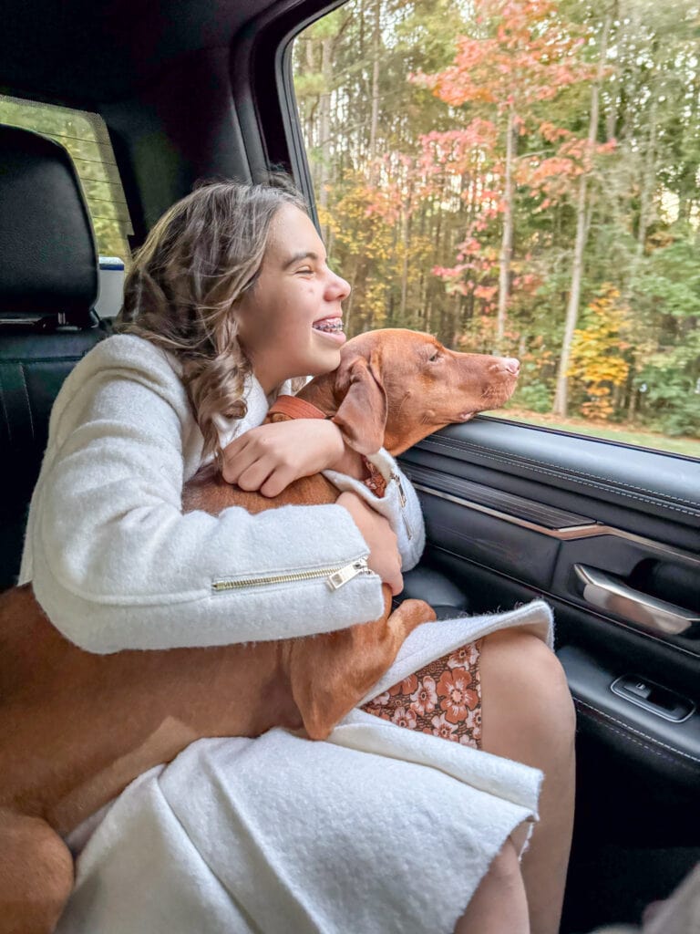 girl holding dog in the car